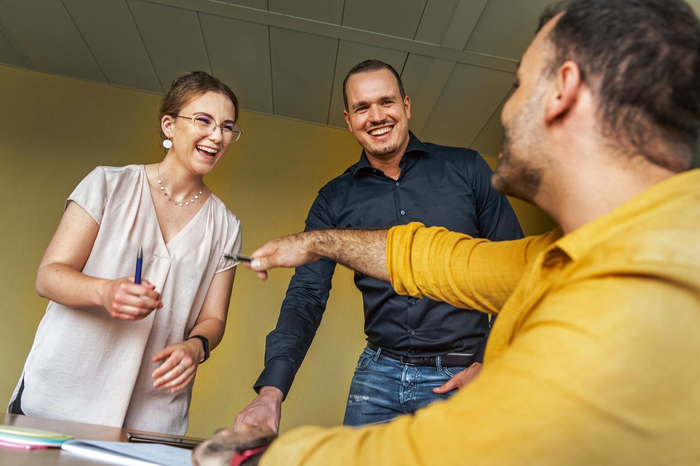 three smiling professionals in a meeting