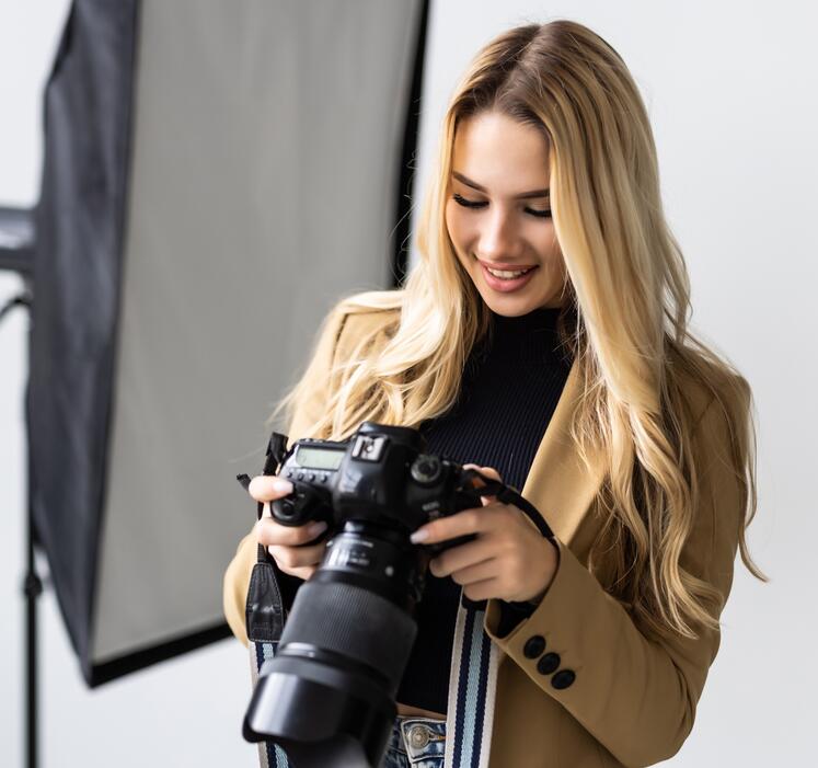 Blonde young woman with camera in hand