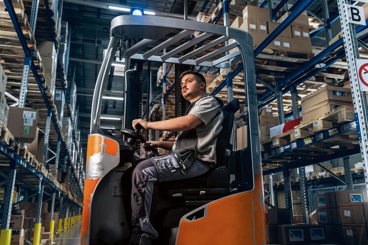 Logistics apprentice driving a forklift truck