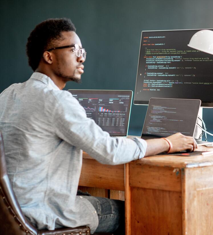 A man works on several devices with code