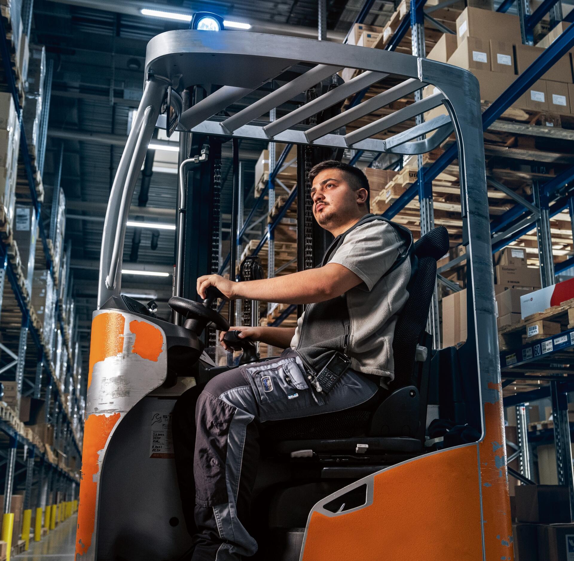 Apprenti en logistique pendant la conduite d'un chariot élévateur