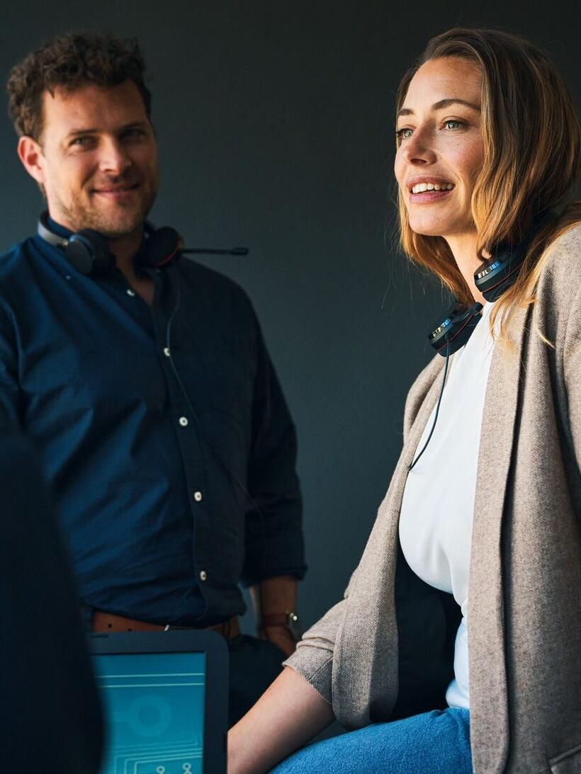 Un’immagine di una donna e un uomo in ufficio mentre lavorano a un progetto, entrambi ridono.
