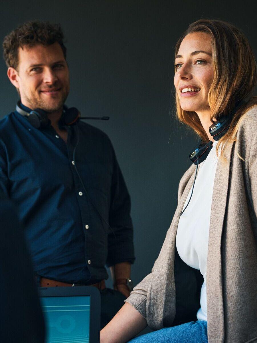 Ein Bild von einer Frau und einem Mann im Büro bei der Projektarbeit, beide lachen